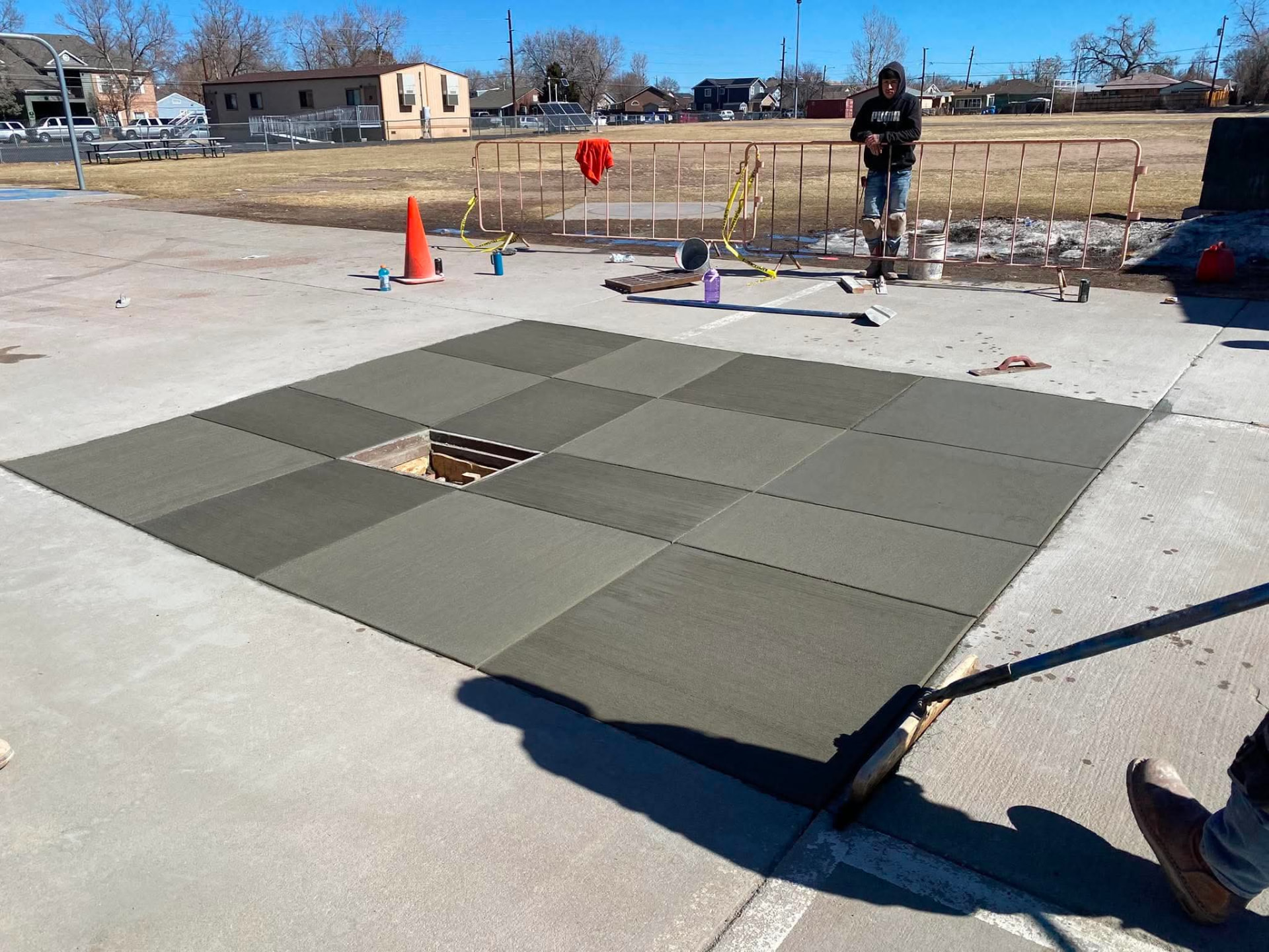 Freshly poured and finished concrete flatwork slab panels at a Colorado school site