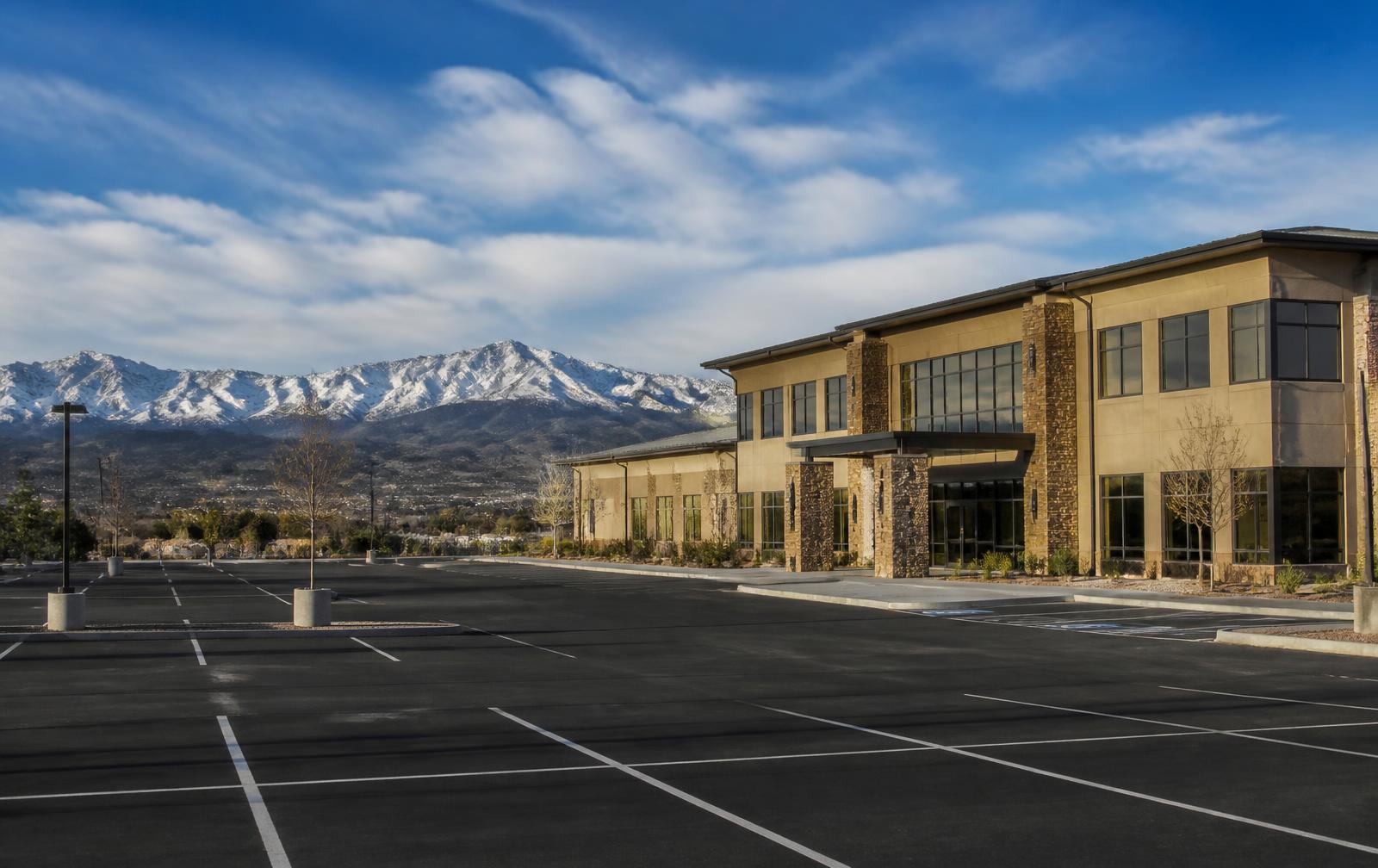 Commercial property in Colorado with a freshly paved parking lot and Front Range mountains