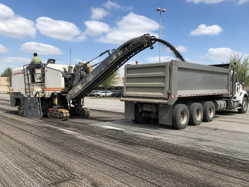 Asphalt milling machine removing an old parking lot surface before overlay